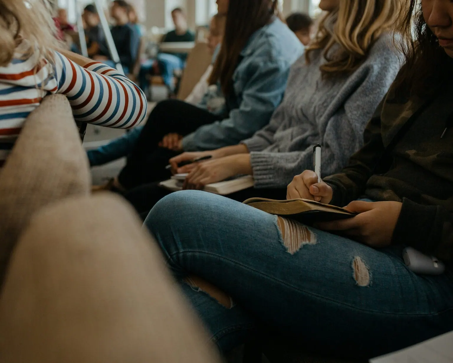 Groupe de jeunes assis en cours, prenant des notes pendant une session de formation