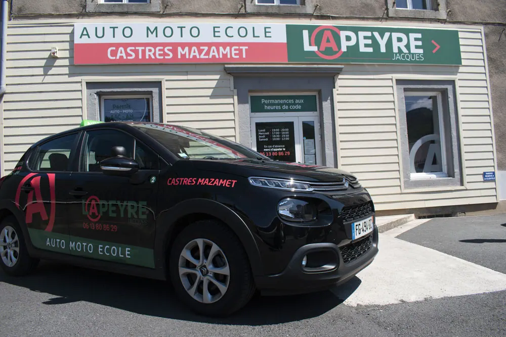 Voiture auto-école Lapeyre garée devant la façade du centre de Mazamet