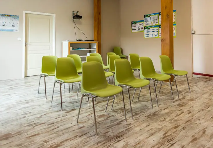 Salle de cours de code de la route équipée de chaises et de tableaux
