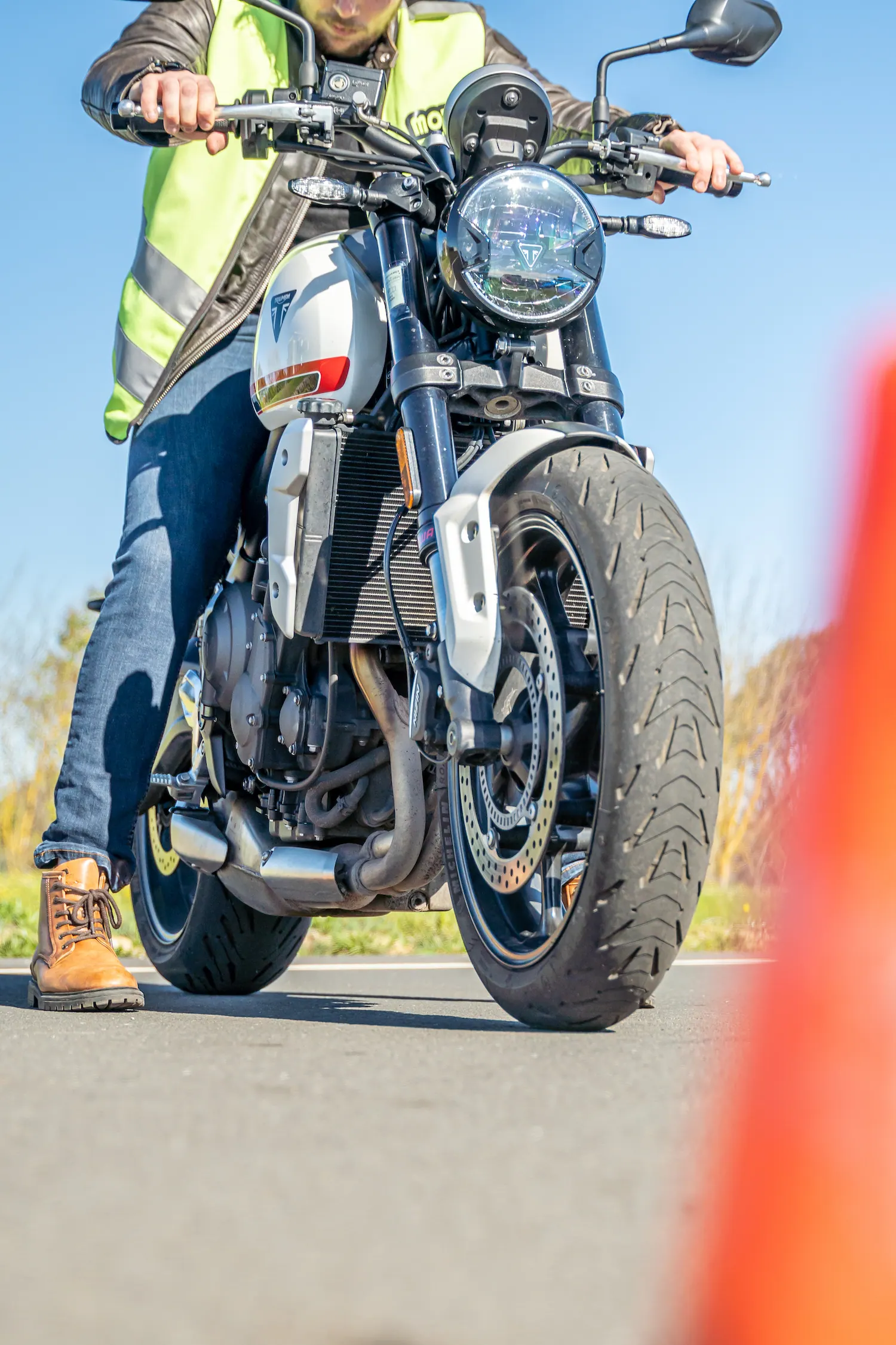 Élève moto en gilet de sécurité au guidon lors de la formation passerelle