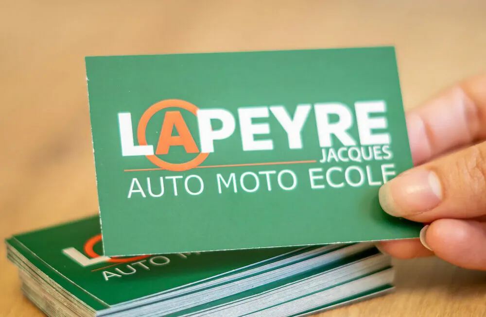 Carte de visite de l'auto-moto école Lapeyre tenue en main