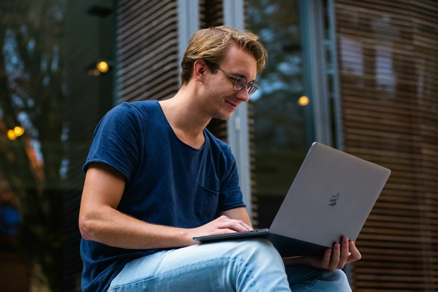 Jeune homme travaillant sur son ordinateur portable en extérieur