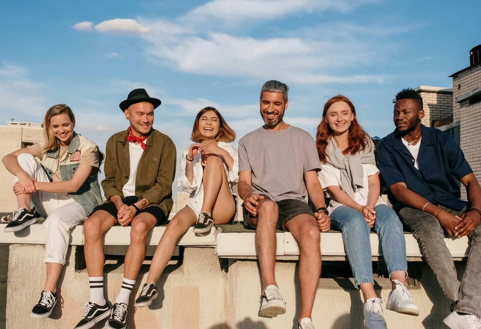 Groupe de jeunes assis côte à côte en extérieur