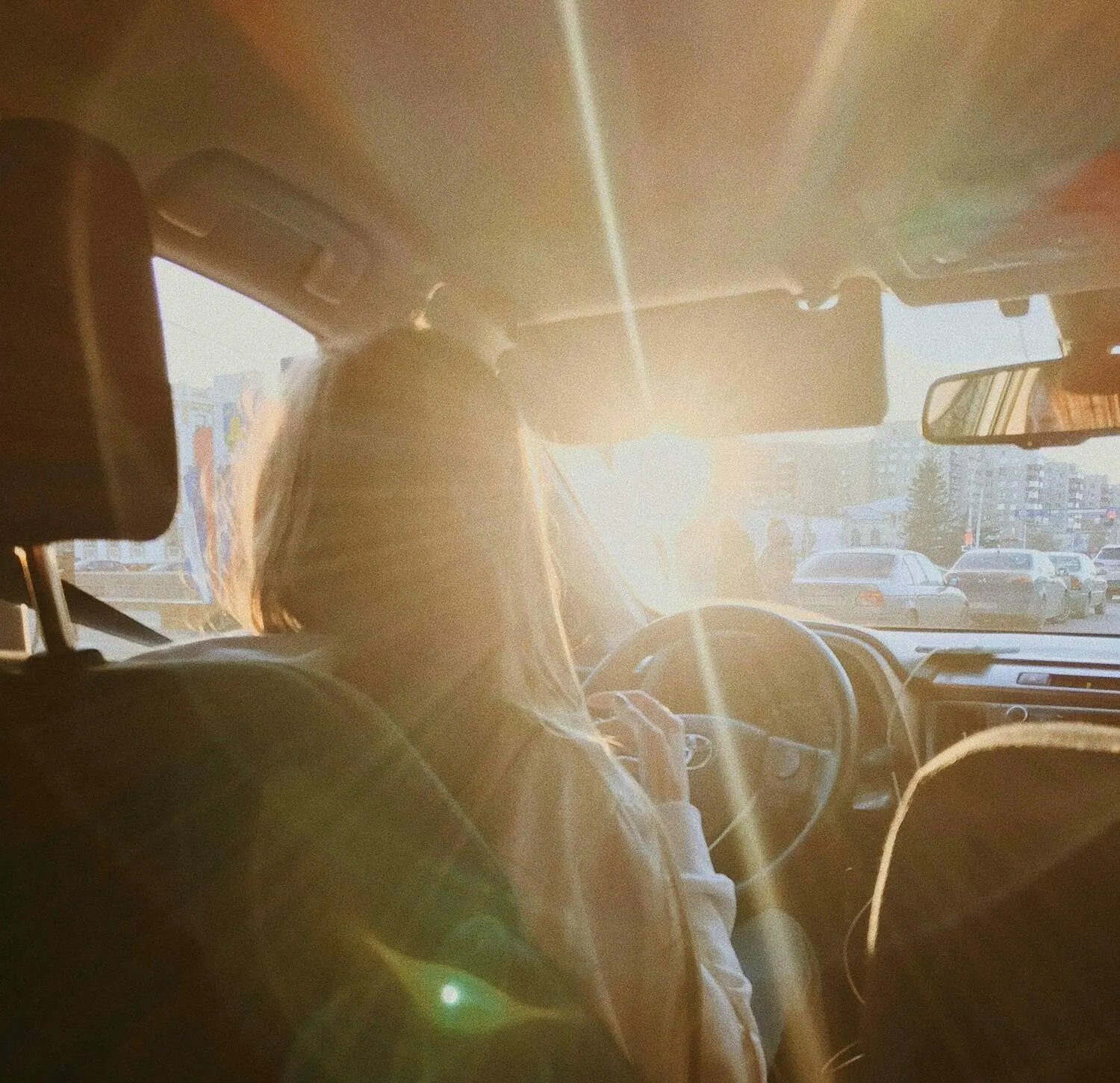 Conductrice au volant à contre-jour au coucher du soleil