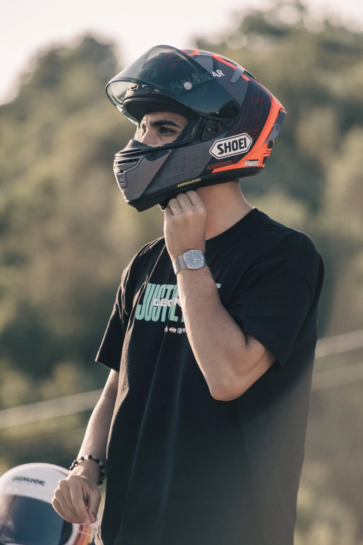 Motard équipé casque et blouson devant un paysage