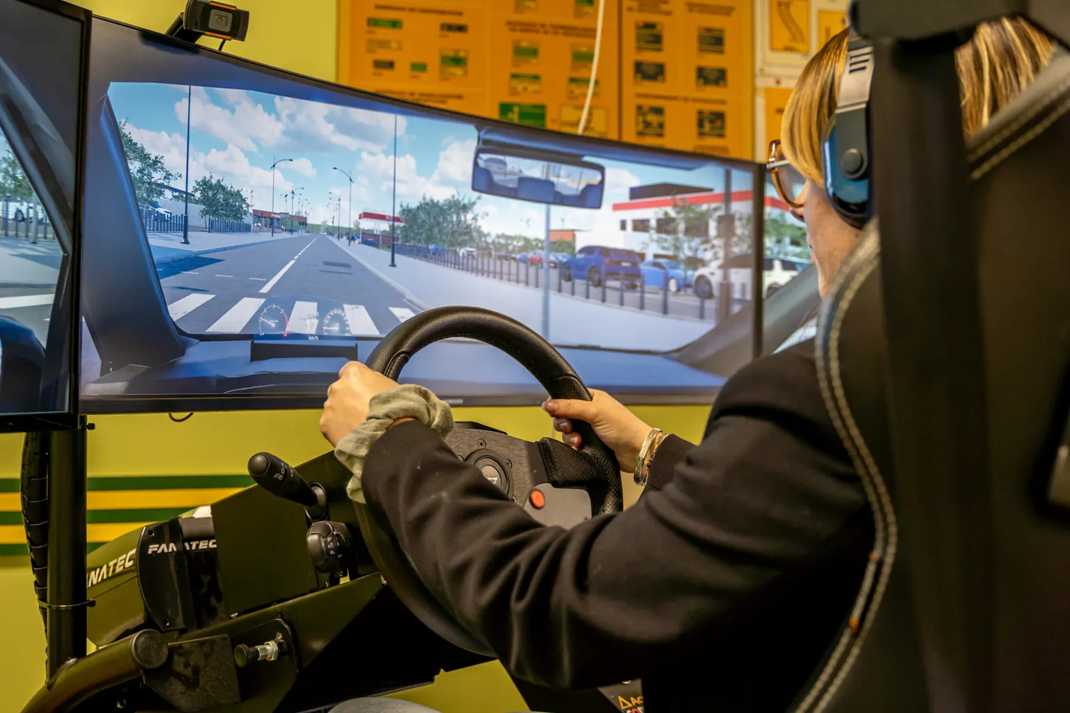 Élève en formation sur le simulateur de conduite à trois écrans